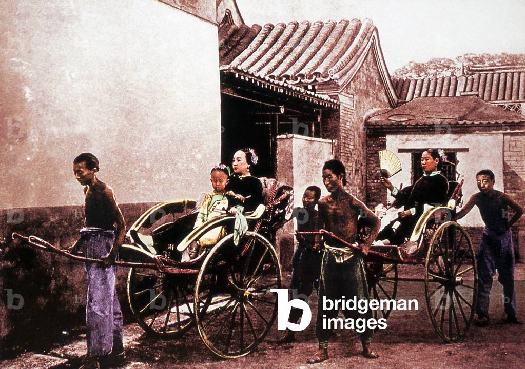 China: Two affluent Chinese women, one with a child, being pulled in rickshaws, Beijing, late Qing Dynasty (c.1890)