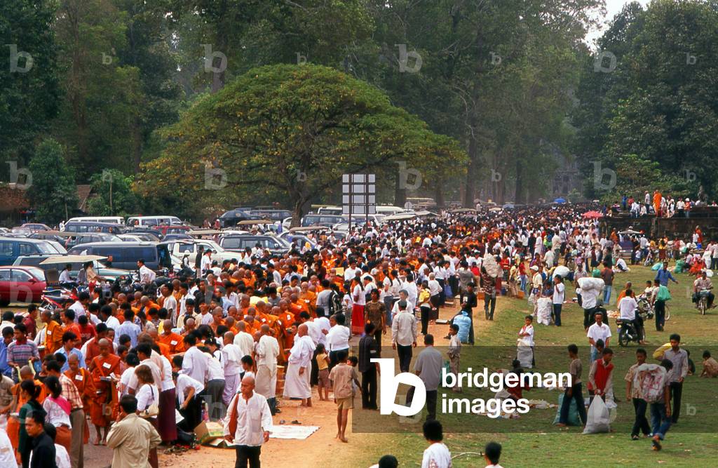 Cambodia: Laypeople and Buddhist monks, nuns and novices congregate after a mass almsgiving ceremony in the heart of Angkor Thom, Angkor