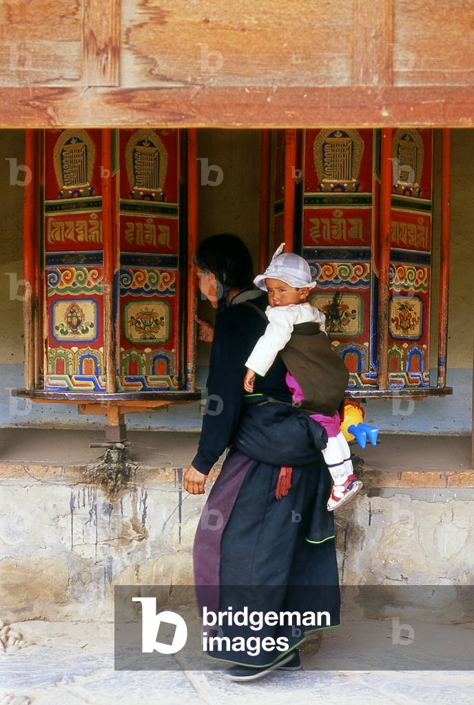 China: Pilgrims circumambulate the monastery while spinning the prayer wheels, Labrang Monastery, Xiahe, Gansu province