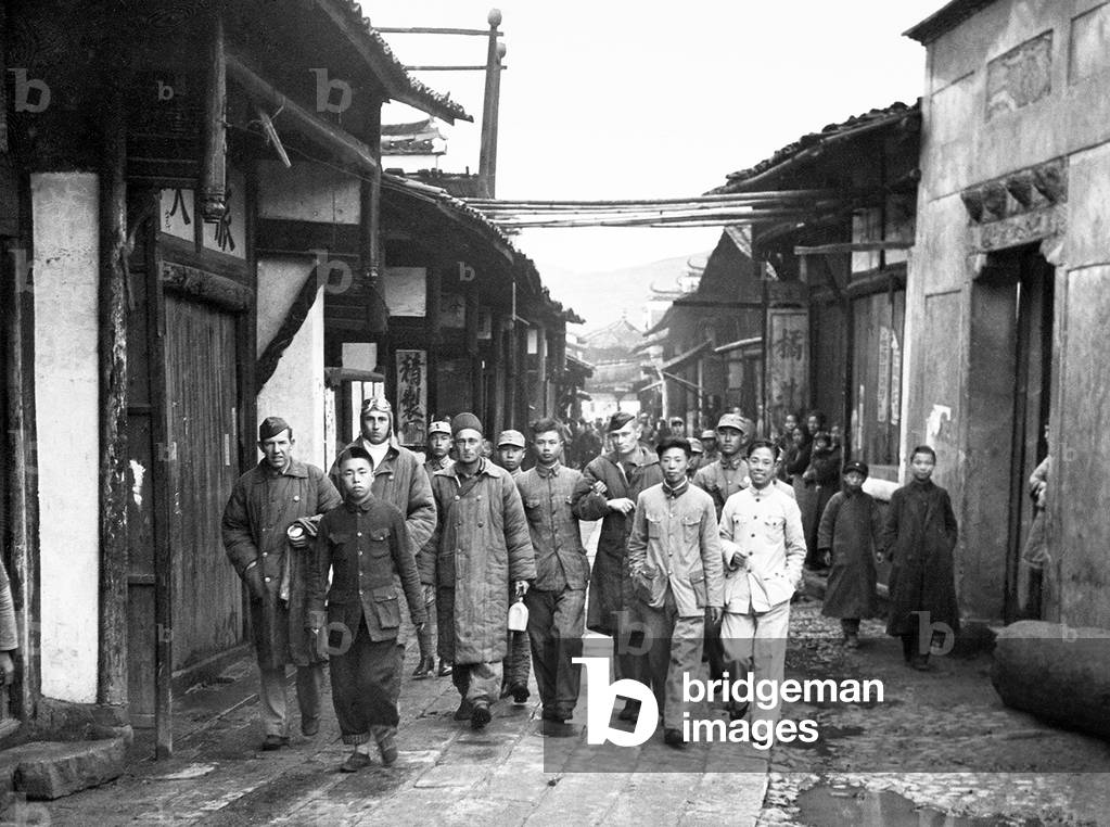 USA / Japan / China: Four unidentified Doolittle Raid crewmen, who bailed out over China from Aircraft no. 14, are escorted through a Chinese town before being reunited with other airmen, April 1942