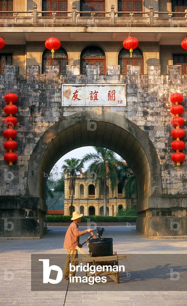 China: Ceremonial Chinese gateway with the old French Customs House in the background, Yongyiguan (Friendship Pass), Chinese - Vietnamese border, near Pingxiang, Guangxi Province