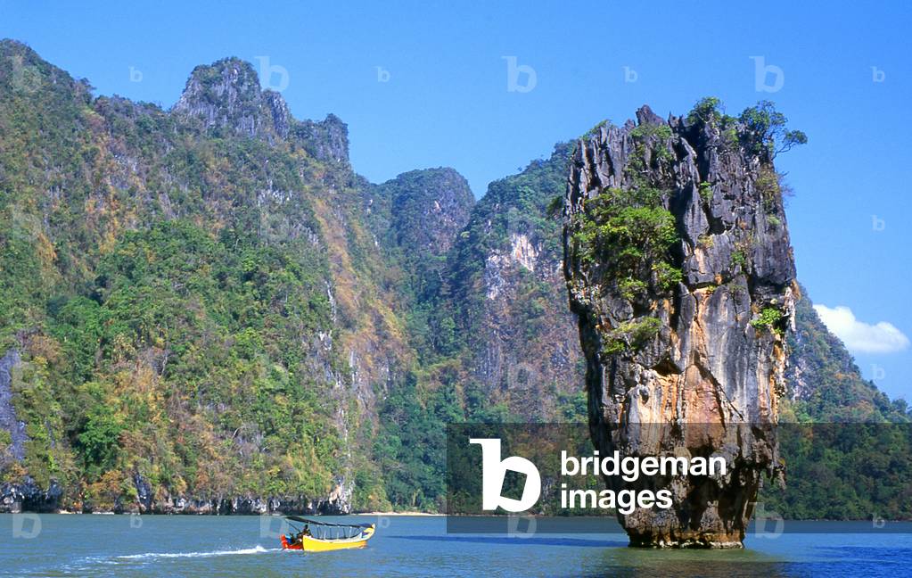 Thailand: Longtail boat passes Ko Tapu (Nail Island) next to Ko Khao Phing Kan (James Bond Island), Ao Phang Nga (Phangnga Bay) National Park, Phang Nga Province