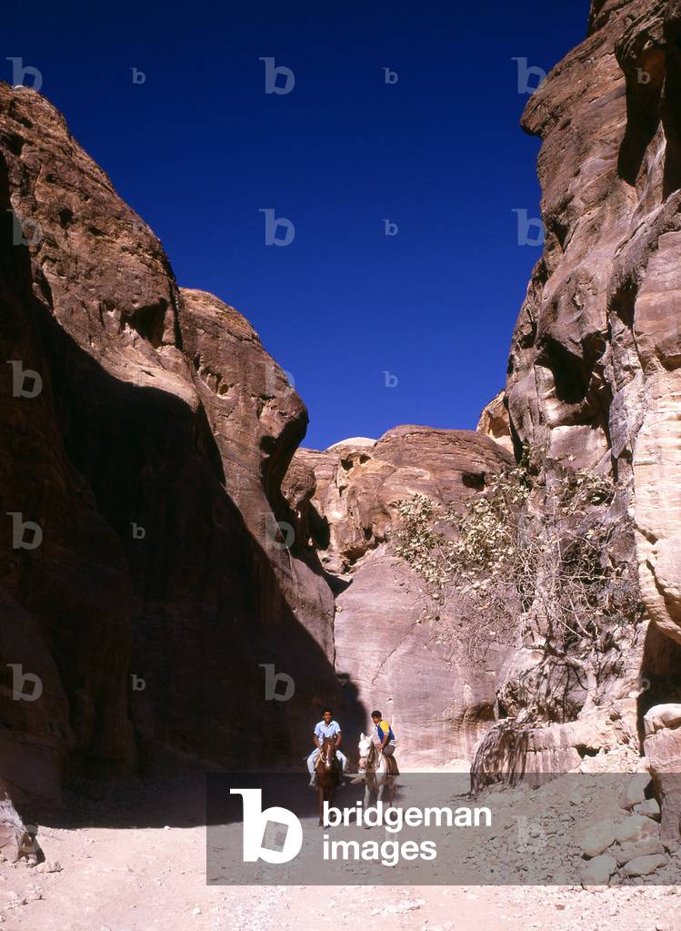 Jordan: Young horsemen in the Siq (shaft) leading to the ancient city of Petra