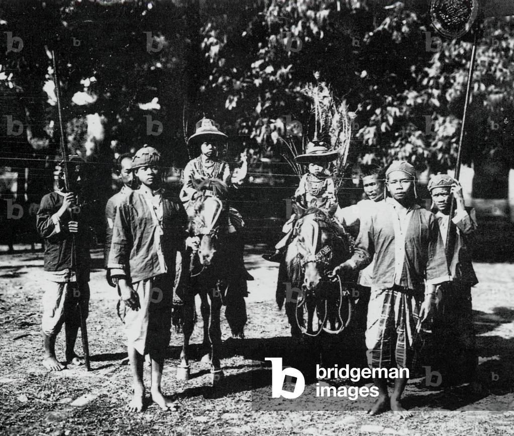 Laos: Two of HM Sisavang Vong's many children take a ride on horses with servants in attendance, photographed in 1919.