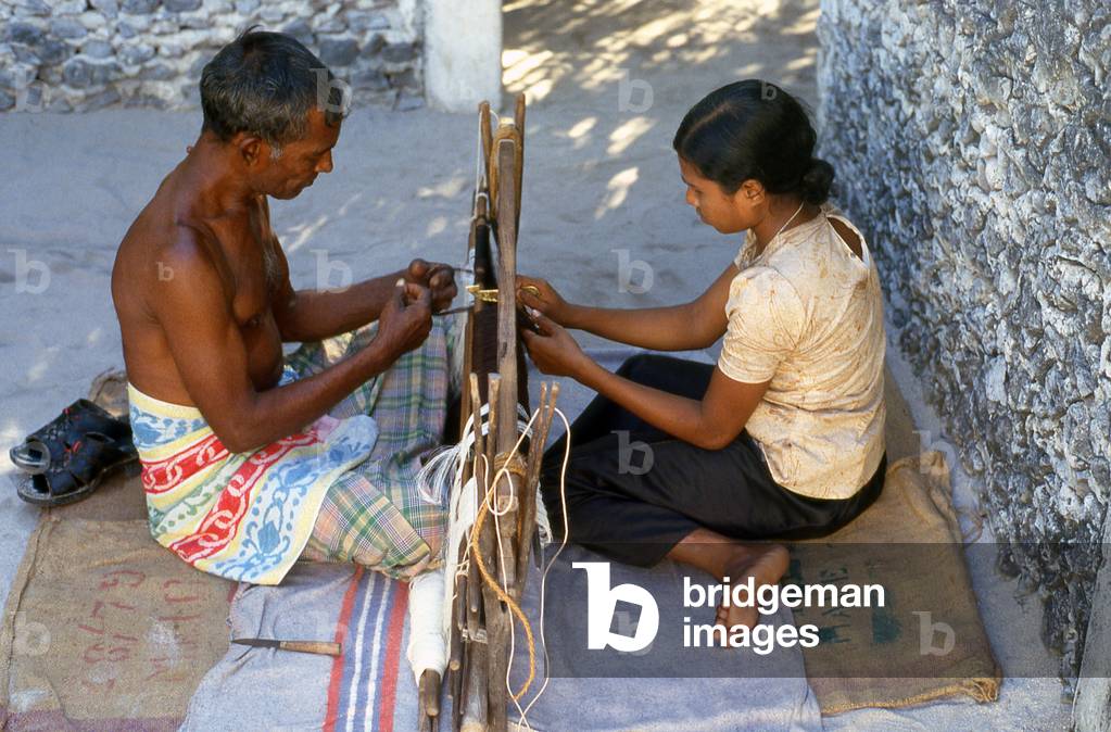Maldives: Preparing a traditional loom for weaving a 