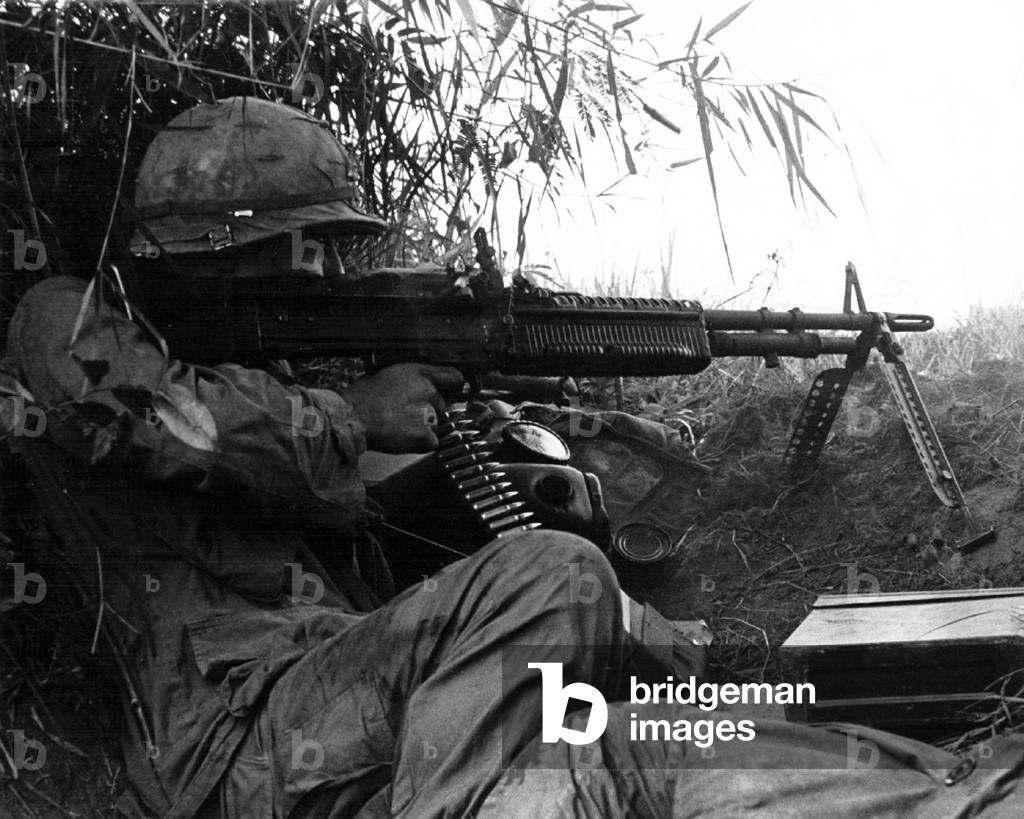 Vietnam: US Army sergeant firing a machine gun during an engagement in South Vietnam, c. 1966