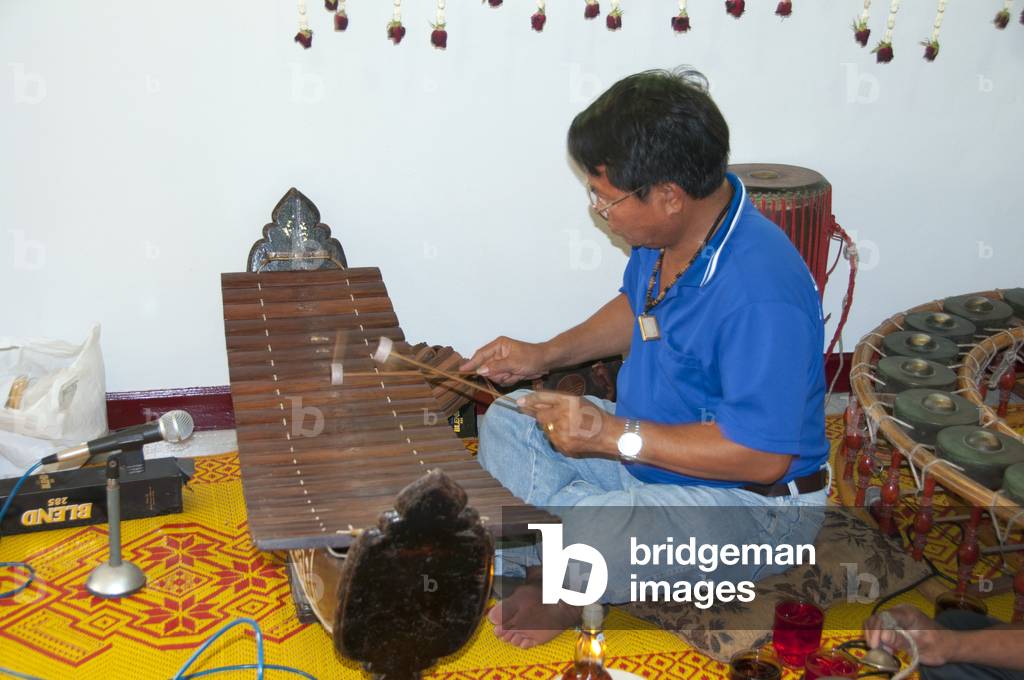 Thailand: Thai Buddhist ordination ceremony, Chiang Mai. A man plays a ranat ek(alto xylophone) in a traditional Thai musical ensemble accompanying the ceremony at the sukhwan nakceremony