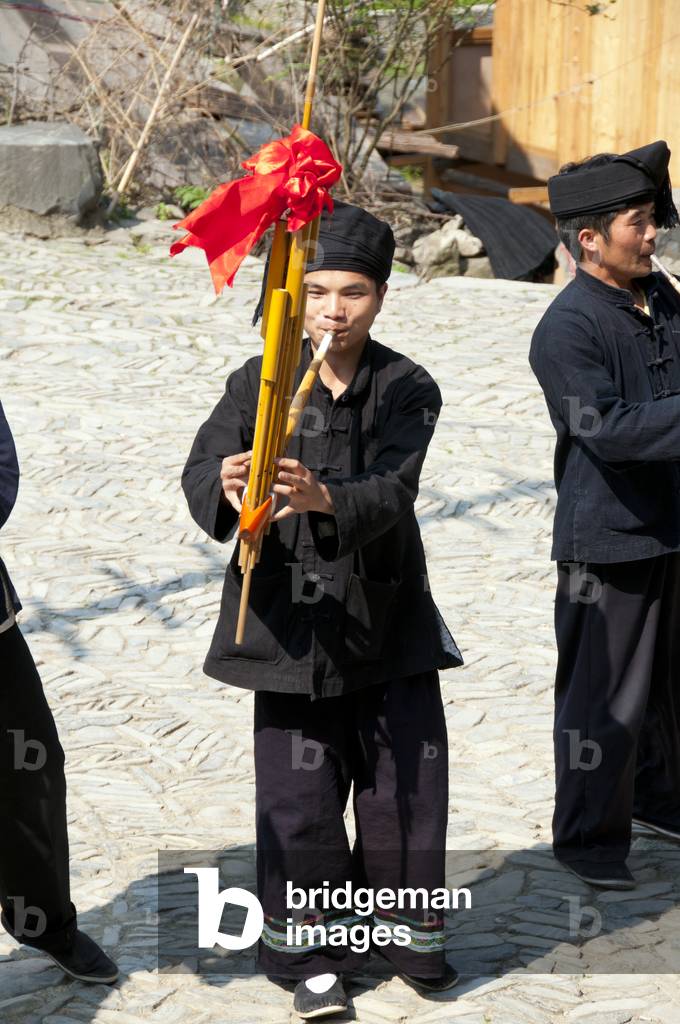 China: Miao man playing the lusheng, a traditonal Miao instrument, in the village of Langde Shang, southeast of Kaili, Guizhou Province