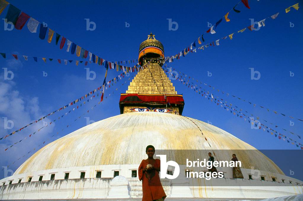 Nepal: Young boy below the all-seeing eyes of the great dome of Bodhnath stupa, Kathmandu