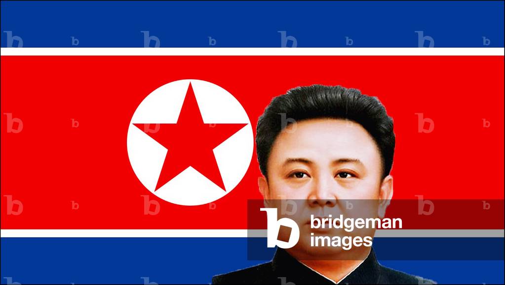 Korea: Pictures of Kim Jong-il, head and shoulders, set against the flag of North Korea (DPRK)