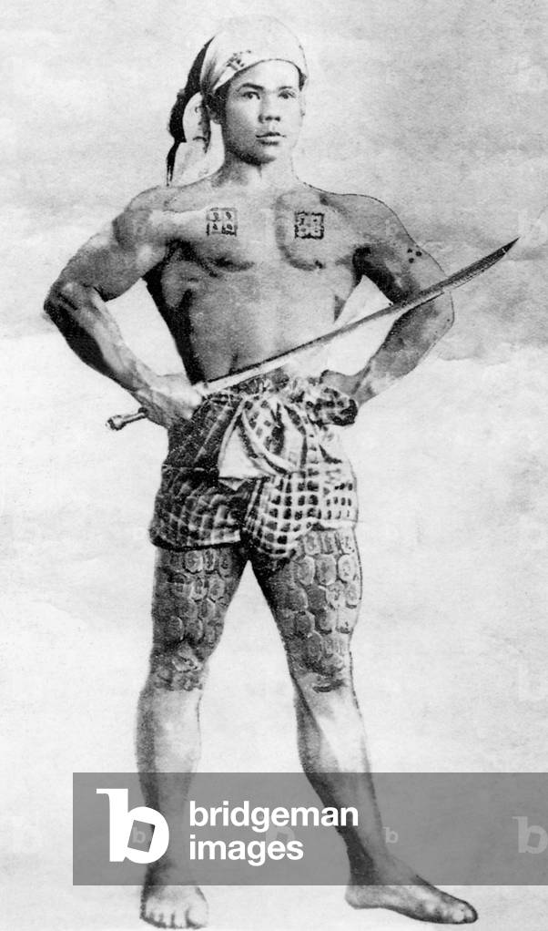 Burma / Myanmar: A tattooed young man poses as a warrior and flexes his muscles for the camera in Mong Un, Shan State, in 1895