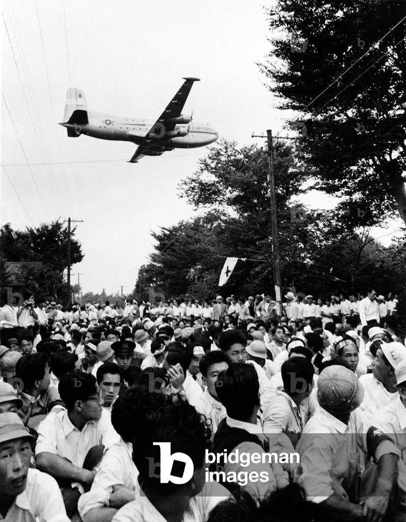 Japan: USAF military transport plane flies over a student sit-in in protest against the expansion of a US military base, Tachikawa, Tokyo. Ken Domon (1909 - 1990), 1955