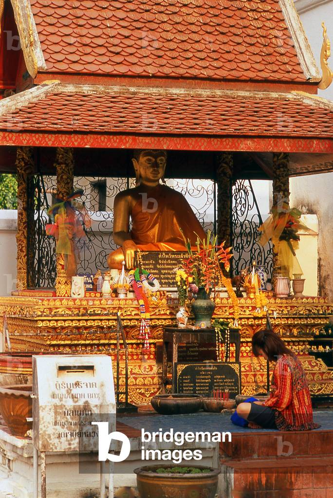 Thailand: Devotee in front of a Buddha shrine in the grounds of Wat Chedi Luang, Chiang Mai
