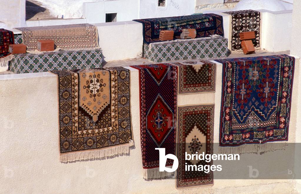 Tunisia: Oriental carpets drying in the sun on the whitewashed walls 0f the Hammamet medina