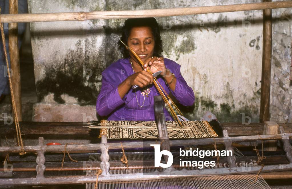 Maldives: Woman weaving a grass 