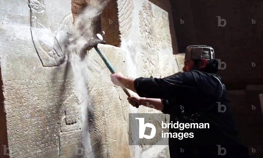 Islamic State / Iraq: An ISIL militant uses a sledgehammer to destroy a bas relief on a wall in Nimrud (1350 - 610 BCE) an ancient Assyrian city in Mosul, northern Iraq, March 2015