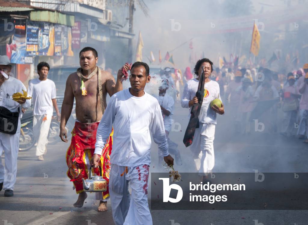 Thailand: Devotees or 'Ma Song' and shrine bearers race through the streets to avoid exploding firecrackers, Phuket Vegetarian Festival
