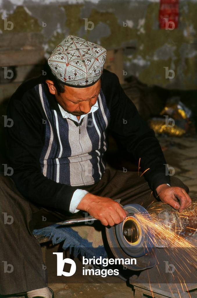 China: Crafting a highly decorative traditional hand-made knife in a small workshop in Yengisar, Xinjiang Province (photo)