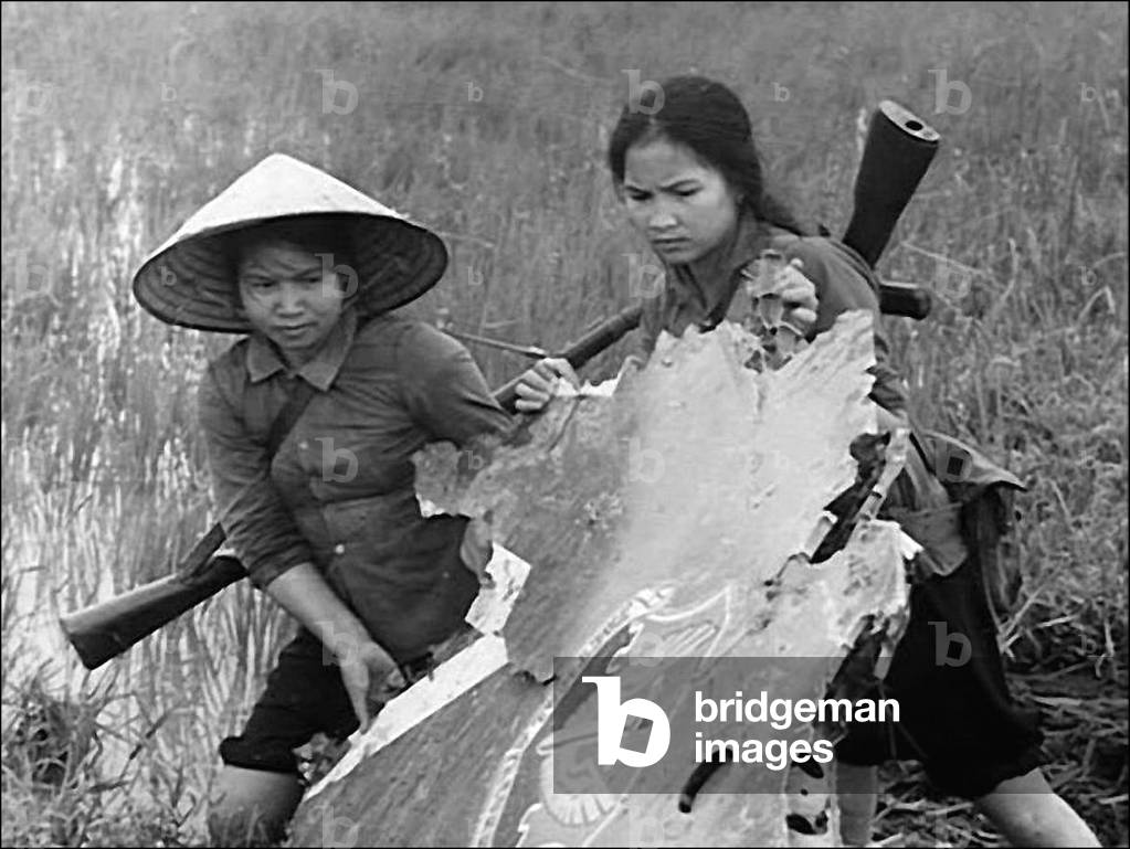 Vietnam: Two National Liberation Front (NLF,  Viet Cong) women fighters salvage wreckage from a downed USAF plane, c.1968