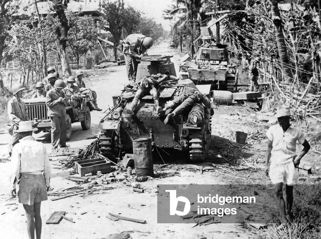 Philippines / USA: US soldiers and Filipino Resistance fighters examine two destroyed Japanese Ha-Go light tanks with their dead crewmen, Binalonan, Pangasinan, Luzon, 29 Jauary 1945 (photo)