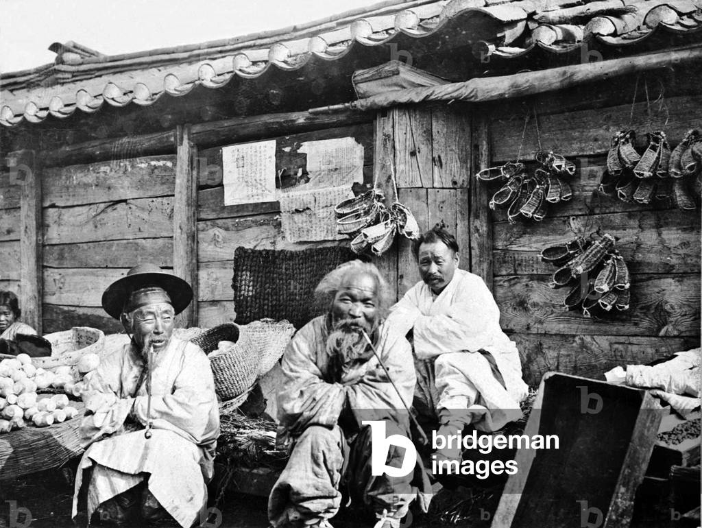 A group of merchants wrapped against the cold weather, Seoul, c.1904