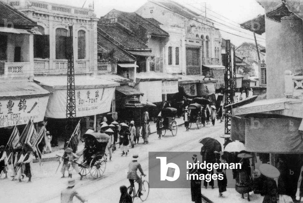 Vietnam: A funeral procession passes through the streets of Hanoi in 1926.