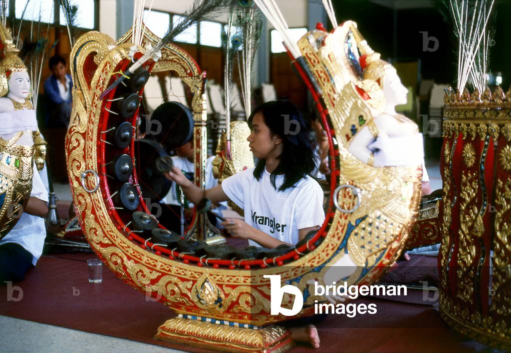 Thailand: A young woman plays the 'khong mon', a gong-circle instrument, in a traditional Thai orchestra, Bangkok
