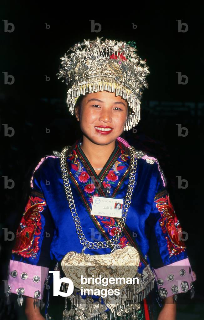 China: Young Miao woman with her distinctive silver headdress at a festival near Guiyang, Guizhou Province