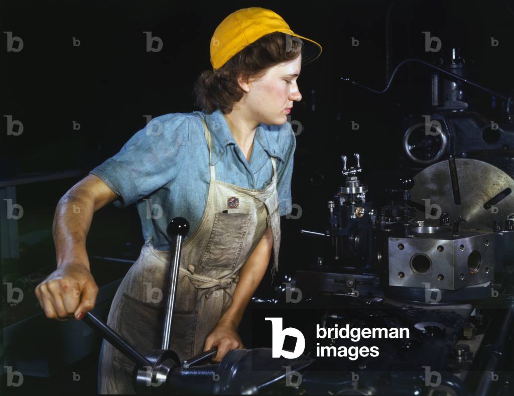 USA: A real life 'Rosie the Riveter' - Turret lathe operator machining parts for transport planes at the Consolidated Aircraft Corporation plant, Fort Worth, Texas, 1942.