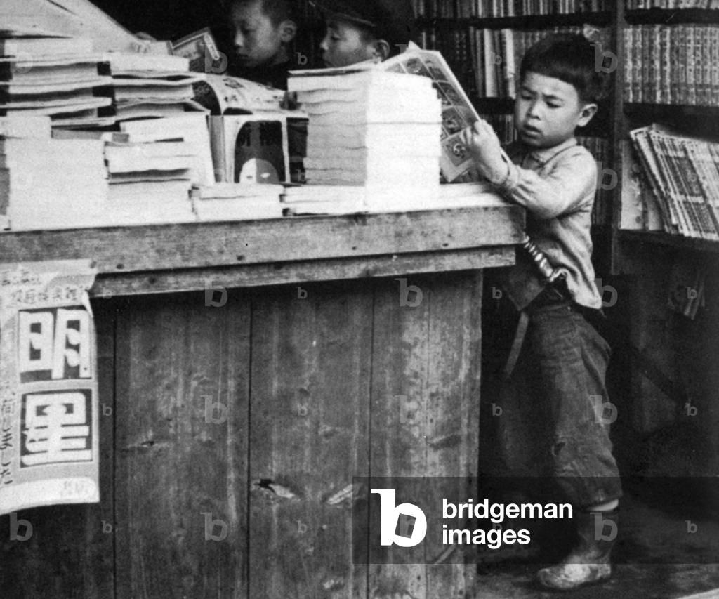 Japan: Post World War II, young boys looking at manga comics in a bookshop.
