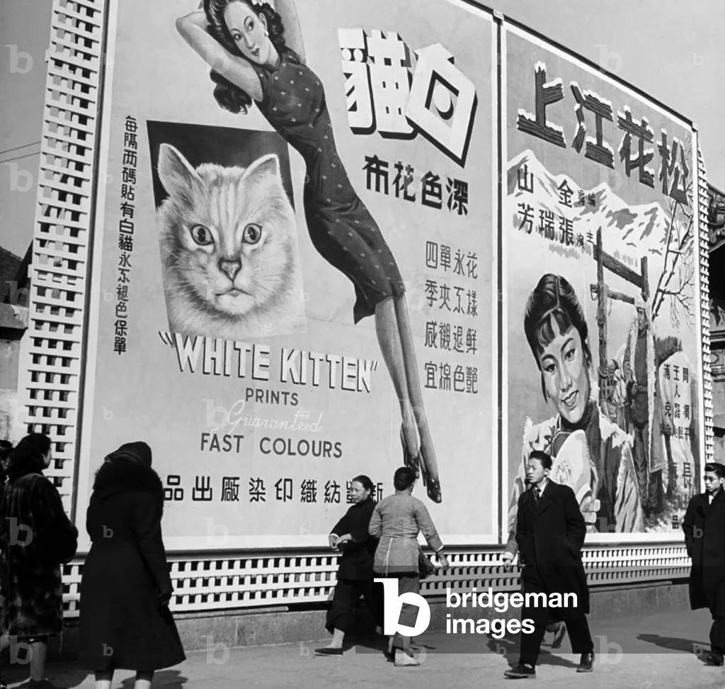 China: Pedestrians walk past an advertising billboard on a Shanghai Street, January 1, 1948