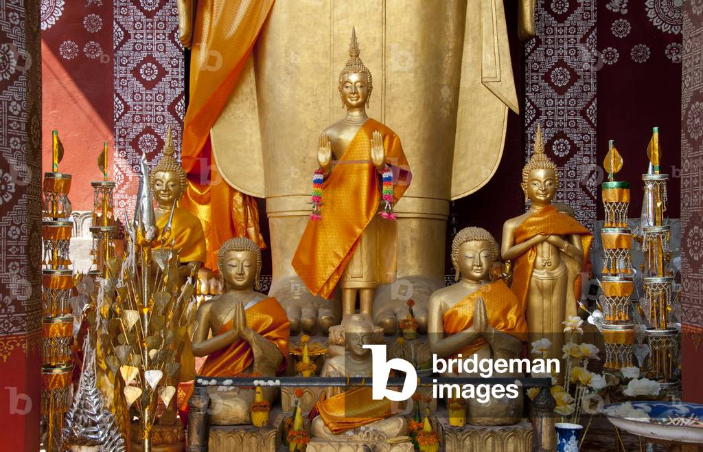 Laos: Buddhas at the feet of the large standing Buddha in outer chapel building, Wat Sene (Saen), Luang Prabang