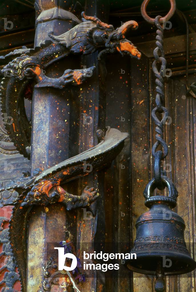 Nepal: A temple bell next to a pillar entwined by a dragon in a Kathmandu Valley temple