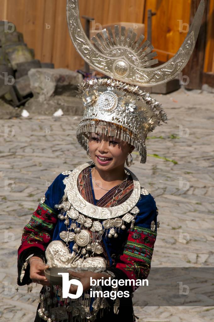 China: Miao woman presents a cup of rice wine in the village of Langde Shang, southeast of Kaili, Guizhou Province