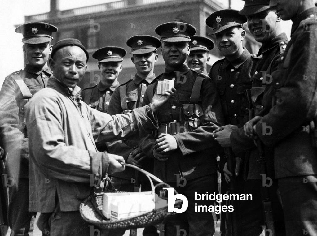 China:  A peddler selling cigarettes to western - probably British - soldiers, Shanghai, 1927