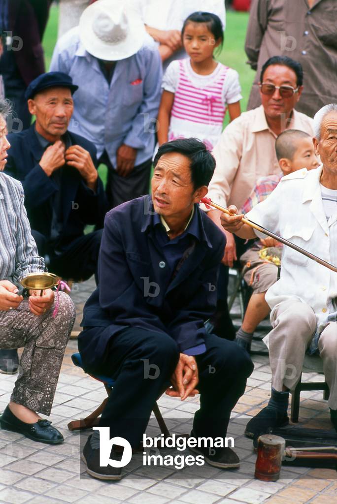 China: Listening to local musicians in Wenhua Square, Wuwei, Gansu Province