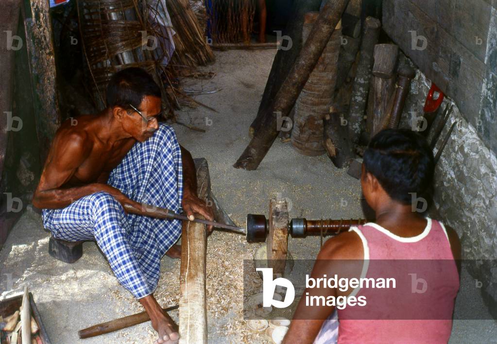 Maldives: Lacquer worker turning a new pot on a traditional lathe, Thulhaadhoo Island, Baa Atoll. This is the only island in the Maldives doing lacquer work, 1980