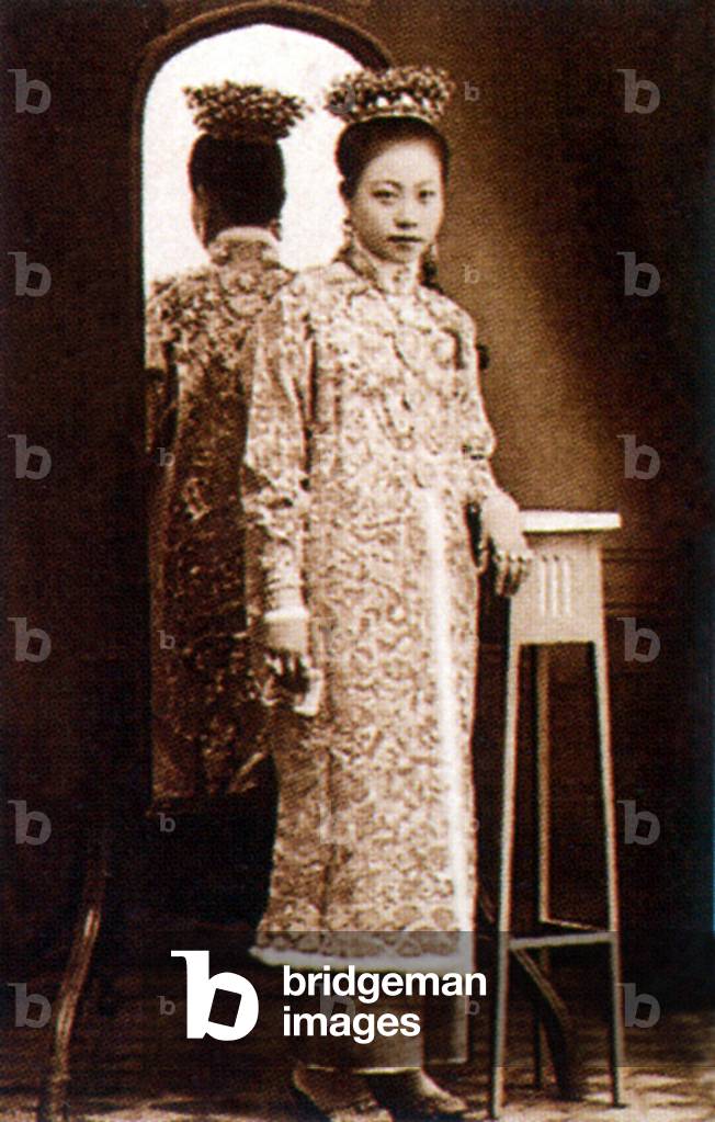 Malaysia / Singapore: A Peranakan bride  poses beside a mirror, Penang, c. 1925