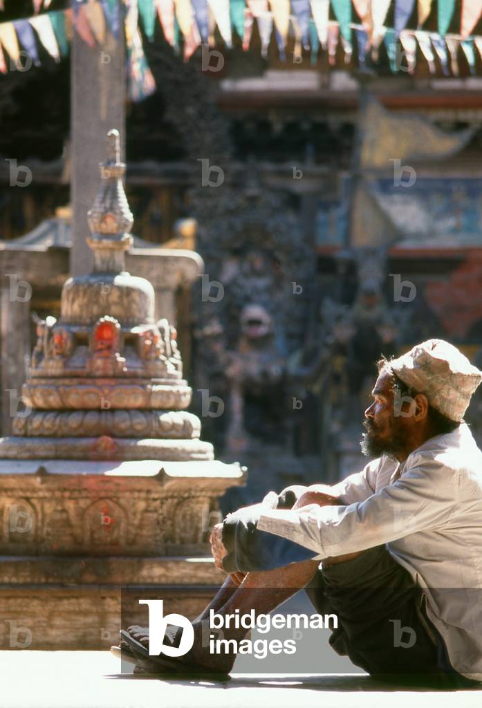 Nepal: A man sits in front of a chaitya (small Buddhist shrine) in the Rudra Varna Mahavihar temple, Patan, Kathmandu Valley (1998)