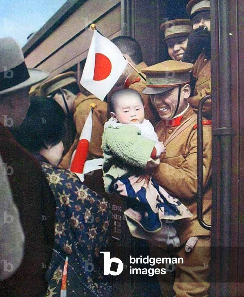 China: A Japanese soldier says goodbye to a young child before boarding a troop train in Manchuria, 1933.