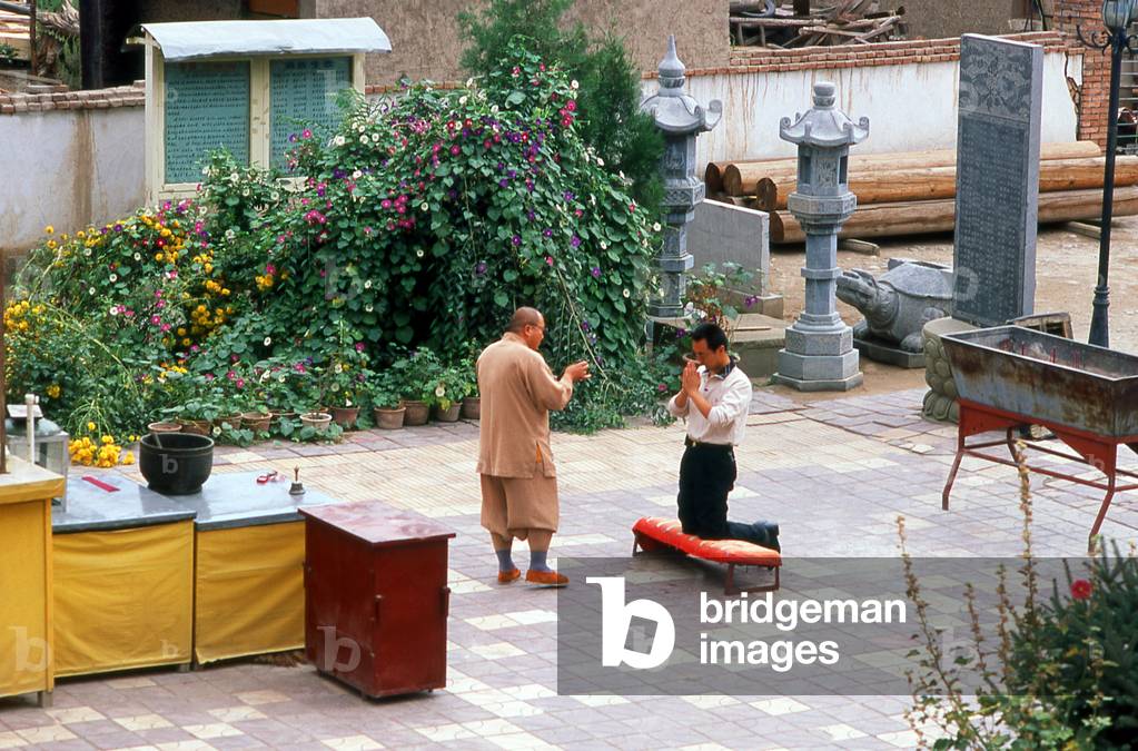 China: A Buddhist monk delivers a blessing at the Luoshi Si Ta (Kumarajiva Pagoda) Buddhist temple, Wuwei, Gansu Province