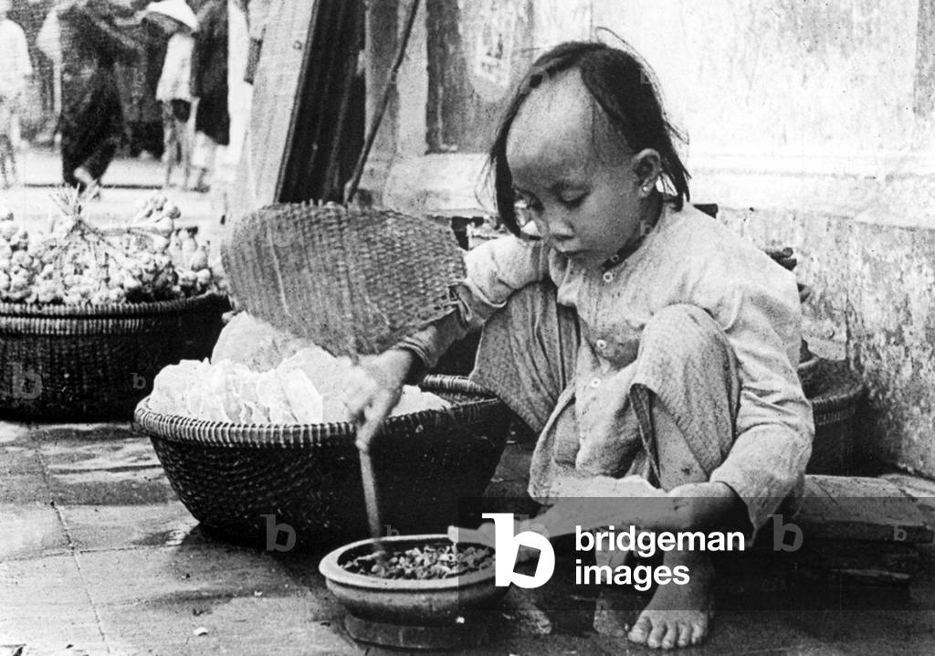 Vietnam: Young girl grilling rice paper, Hoi An (1940)