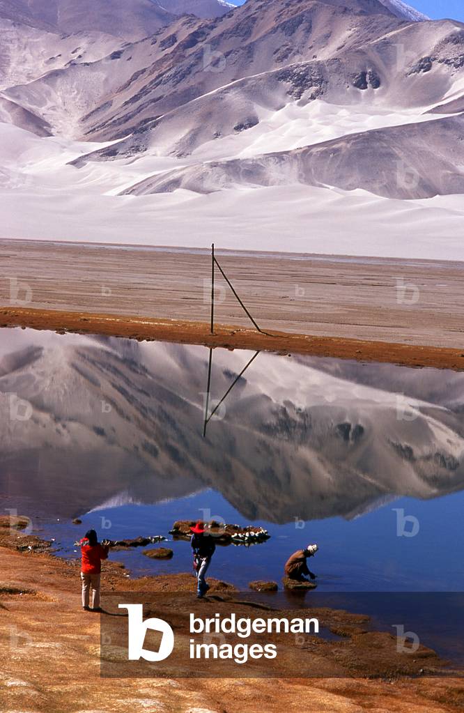 China: Tourists and a Kirghiz man near the Kangxiwa River high up in the Pamir Mountains, Karakoram Highway, Xinjiang