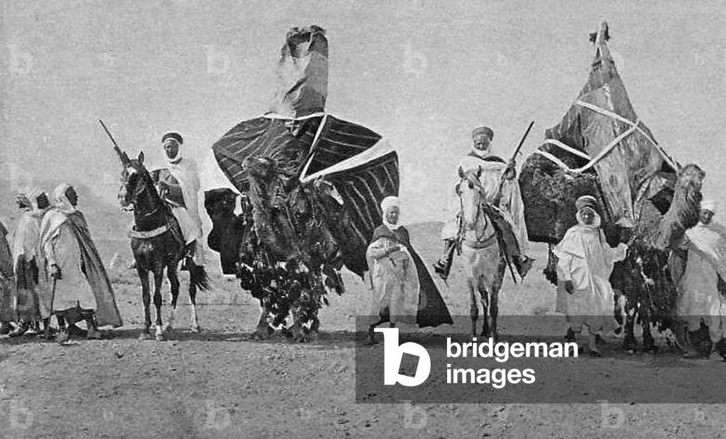 Algeria: Armed Berber riders and camels in the Sahara, early 20th century