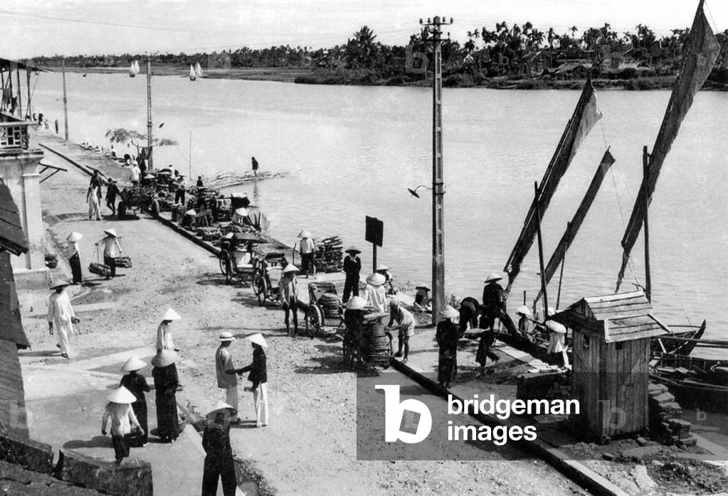Vietnam: Cyclo drivers and vendors by the Thu Bon River in downtown Hoi An (c. 1950)