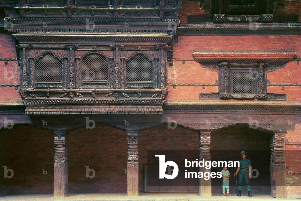 Nepal: A young boy and soldier stand guard at the Old Royal Palace (Hanuman Dhoka Palace), off Durbar Square, Kathmandu