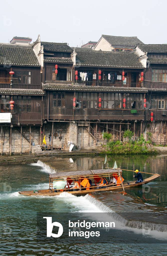 China: A tourist boat goes over a weir on the Tuo River, Fenghuang, Hunan Province