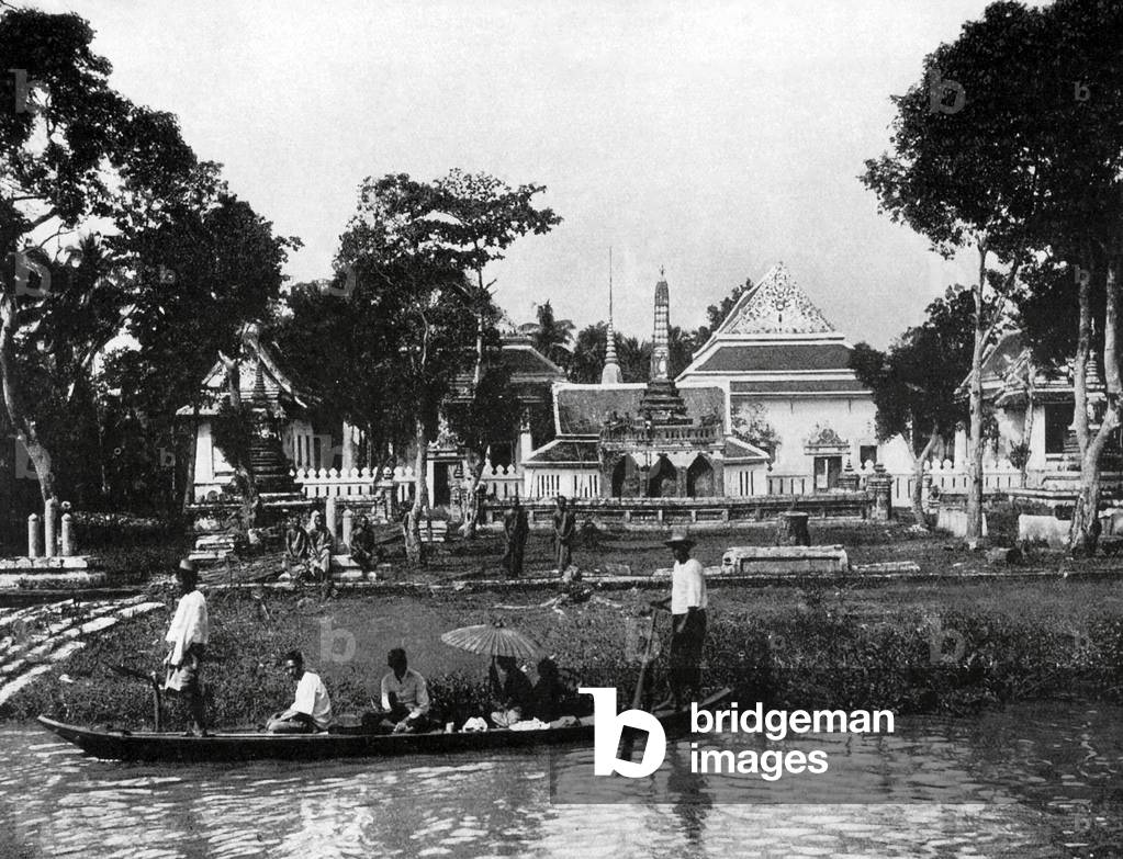 Thailand: A small passenger boat outside a Buddhist temple near Bangkok, c. 1900.