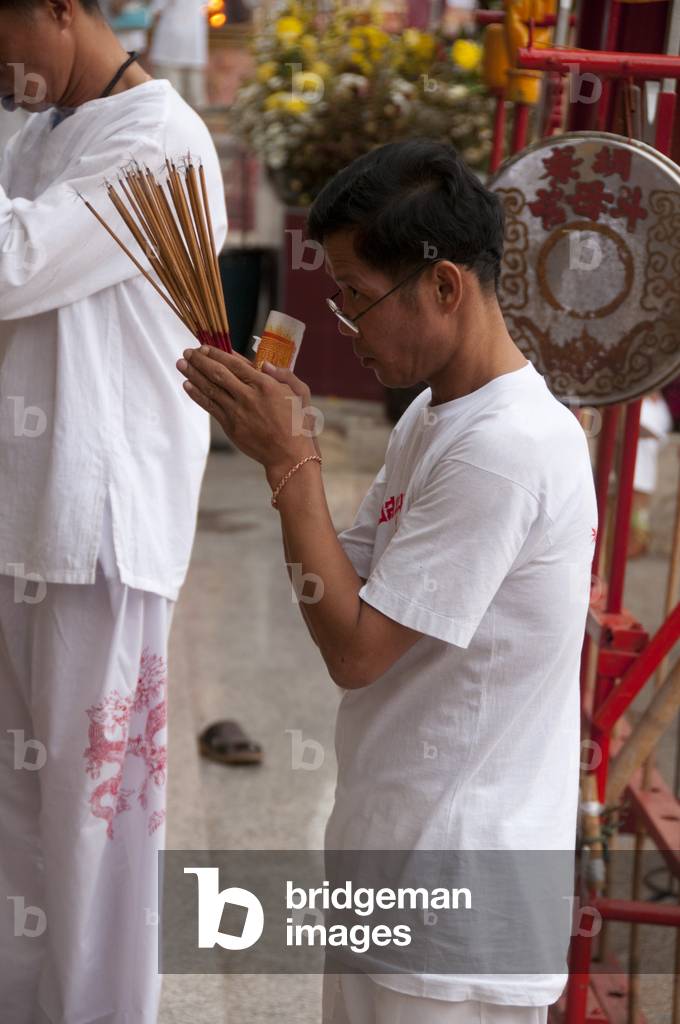 Thailand: A devotee at prayer in San Chao Bang Niew (Chinese Taoist temple), Phuket Vegetarian Festival