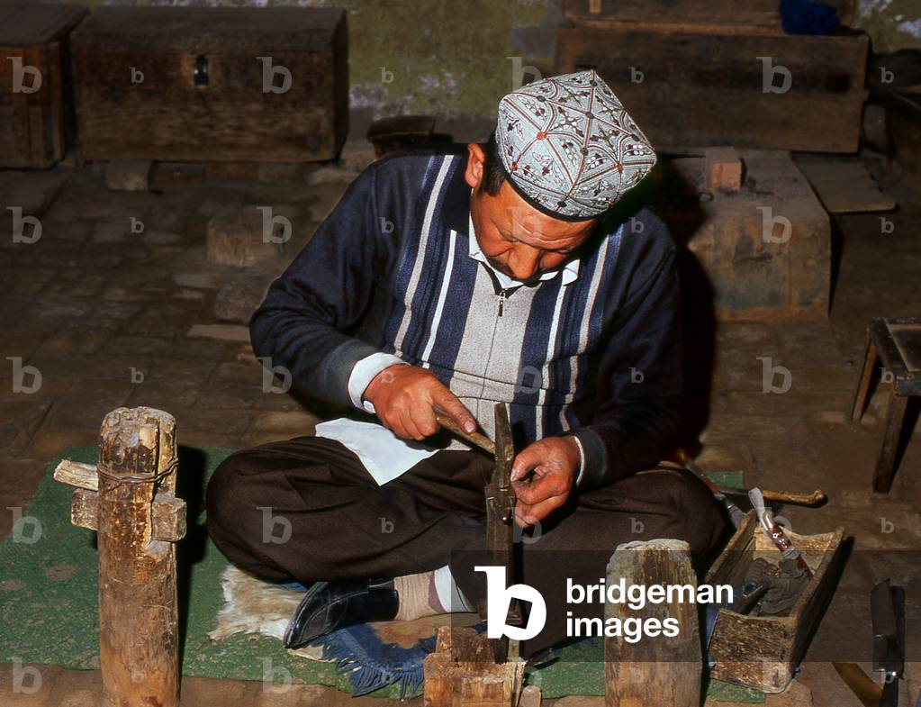 China: Crafting a highly decorative traditional hand-made knife in a small workshop in Yengisar, Xinjiang Province (photo)